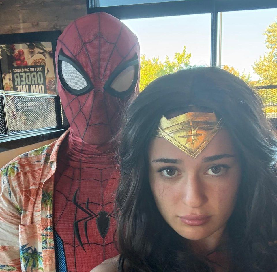 Jess as a Wonder Woman-inspired hero next to a web-slinging hero at a party